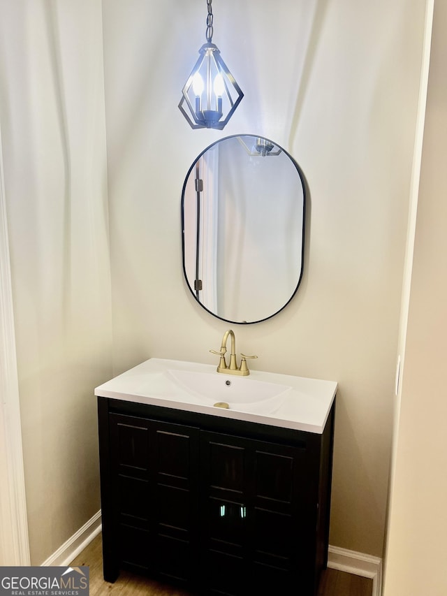 bathroom featuring baseboards, wood finished floors, and vanity