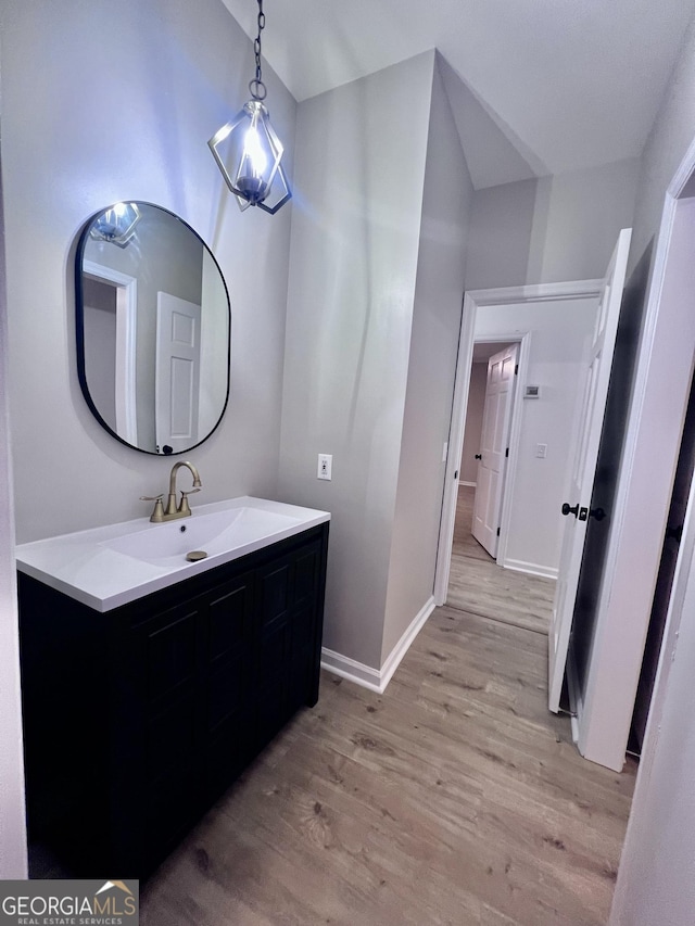 bathroom featuring wood finished floors, vanity, and baseboards