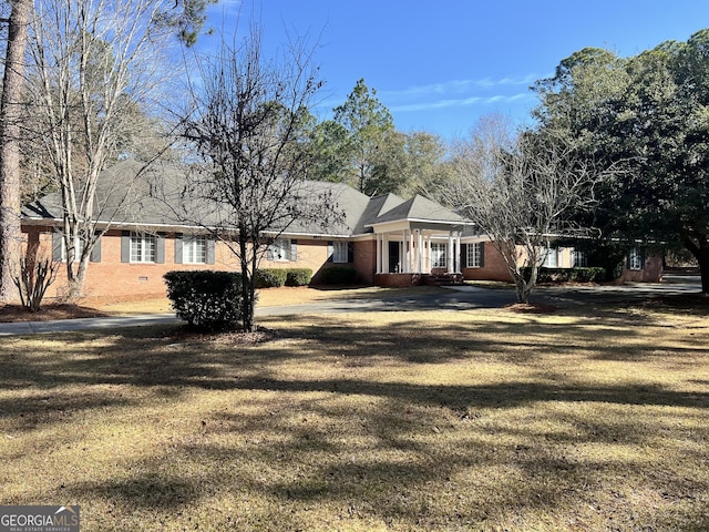 ranch-style house with a front yard and brick siding