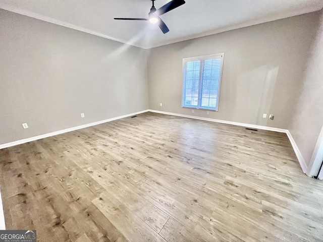 empty room featuring light wood-style flooring, crown molding, baseboards, and a ceiling fan