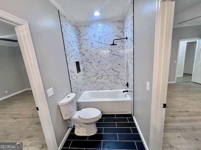 full bathroom featuring toilet, wood finished floors, baseboards, washtub / shower combination, and crown molding