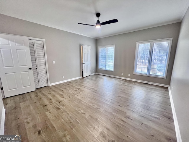 unfurnished bedroom featuring light wood finished floors, baseboards, ornamental molding, and ceiling fan