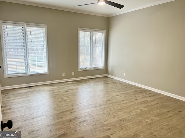 empty room with light wood-style flooring, ornamental molding, ceiling fan, and baseboards