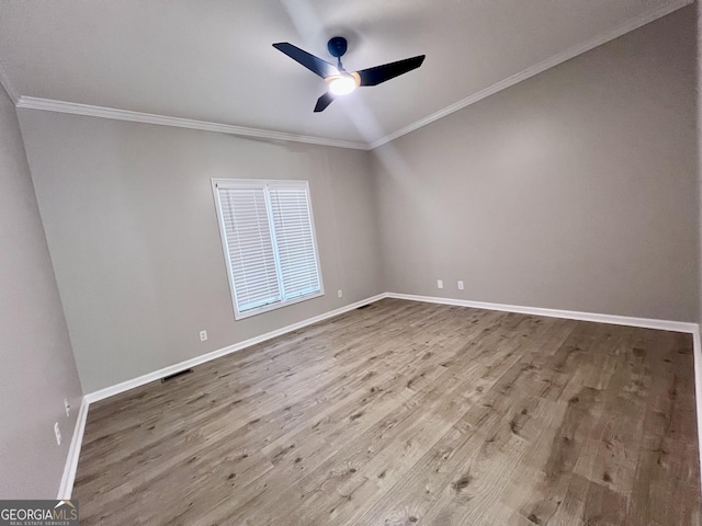 empty room featuring ceiling fan, ornamental molding, wood finished floors, and baseboards