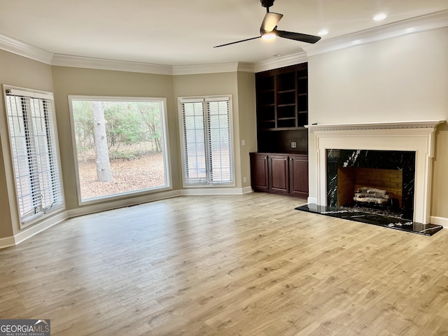 unfurnished living room featuring light wood-type flooring, a fireplace, and crown molding