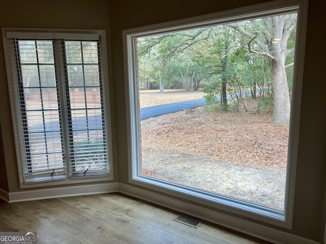 doorway to outside with wood finished floors, visible vents, and baseboards