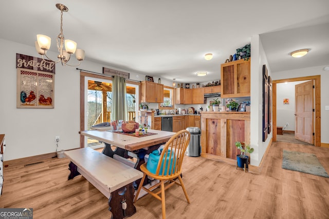 dining space with an inviting chandelier and light hardwood / wood-style flooring