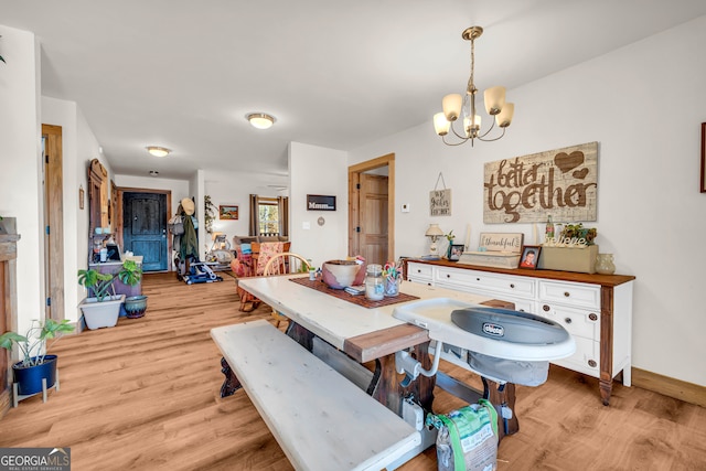 dining area with an inviting chandelier and light hardwood / wood-style floors