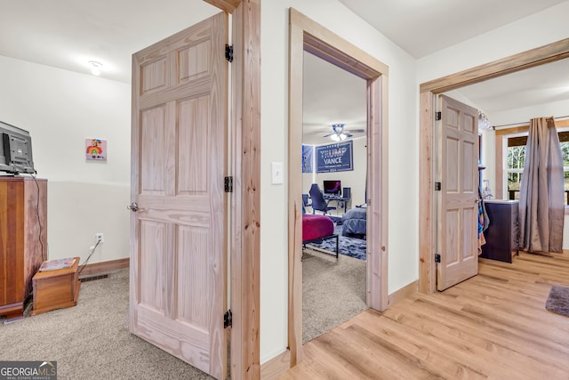 corridor with light hardwood / wood-style floors