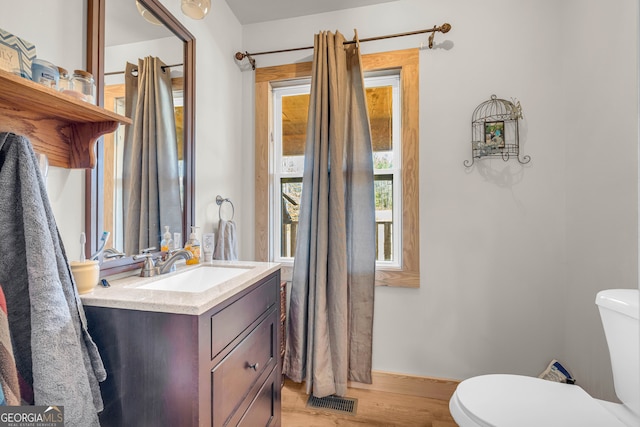 bathroom with vanity, hardwood / wood-style floors, and toilet