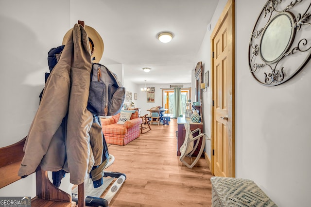 hall featuring hardwood / wood-style floors and a chandelier