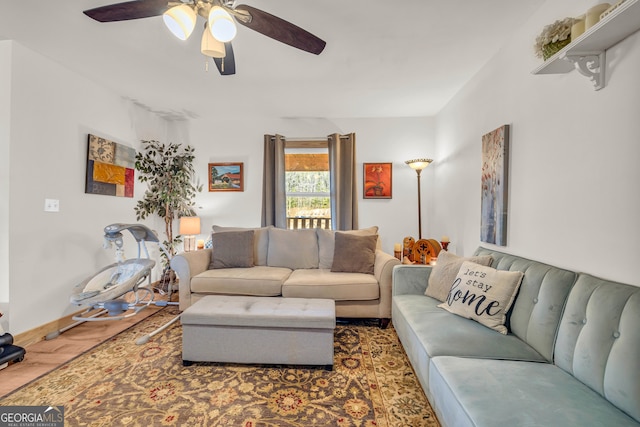 living room featuring dark wood-type flooring and ceiling fan