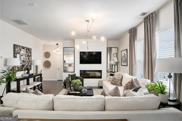 living room with a chandelier, hardwood / wood-style floors, and a fireplace