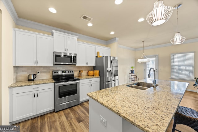 kitchen featuring stainless steel appliances, an island with sink, and sink