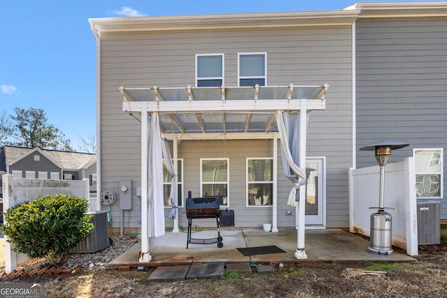 rear view of house featuring a patio, a jacuzzi, central AC unit, and a pergola