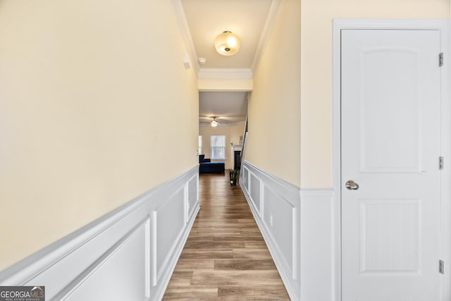 corridor featuring ornamental molding and light hardwood / wood-style floors