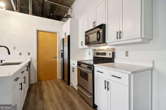 kitchen featuring white cabinetry, sink, dark wood-type flooring, and stainless steel appliances