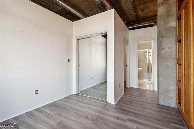 unfurnished bedroom with hardwood / wood-style flooring and a closet