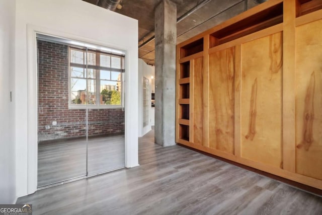 interior space featuring hardwood / wood-style flooring and brick wall