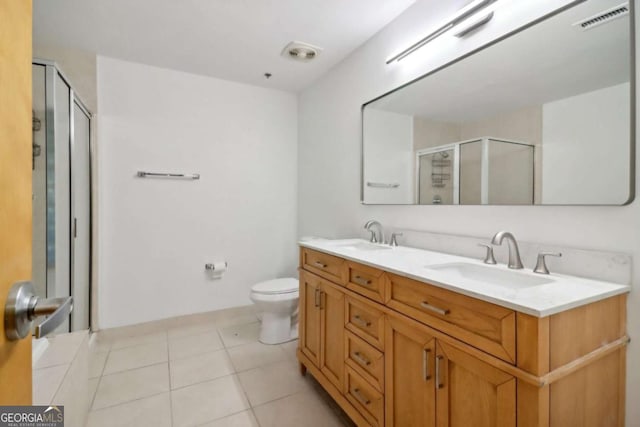 bathroom with an enclosed shower, vanity, tile patterned floors, and toilet