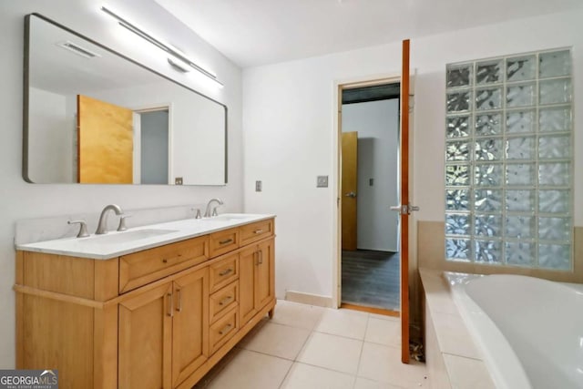 bathroom featuring vanity, tiled tub, and tile patterned floors