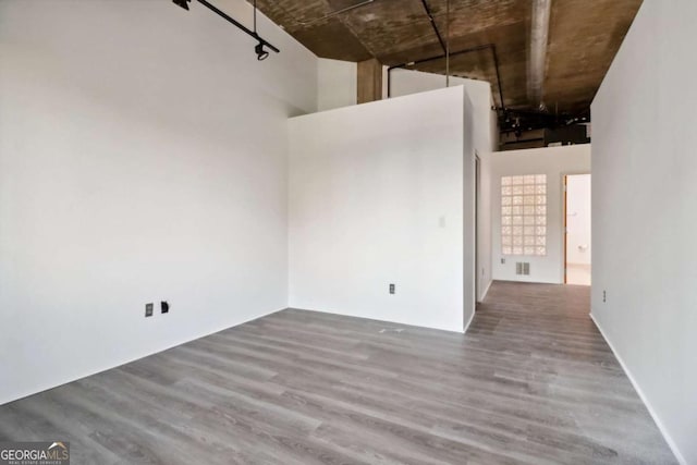 empty room featuring hardwood / wood-style flooring and a high ceiling