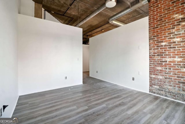 interior space featuring hardwood / wood-style floors and brick wall