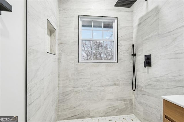 bathroom with vanity and tiled shower