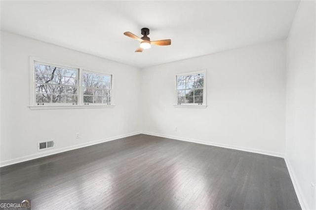 spare room featuring dark wood-type flooring and ceiling fan