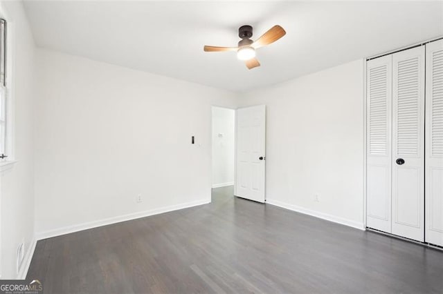 unfurnished bedroom with dark wood-type flooring, ceiling fan, and a closet