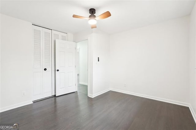 unfurnished bedroom featuring dark wood-type flooring, ceiling fan, and a closet