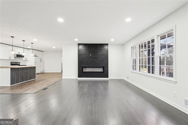 unfurnished living room featuring a fireplace and dark hardwood / wood-style floors