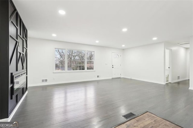 unfurnished living room with dark wood-type flooring