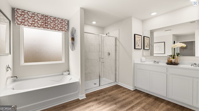 bathroom with hardwood / wood-style floors, separate shower and tub, and vanity