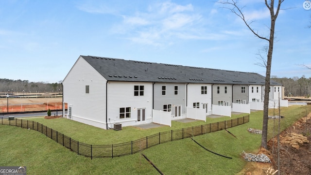 back of house featuring a lawn and central air condition unit