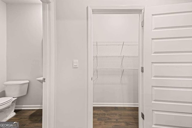 interior space featuring hardwood / wood-style flooring and toilet