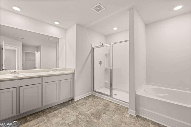 bathroom featuring plus walk in shower and vanity