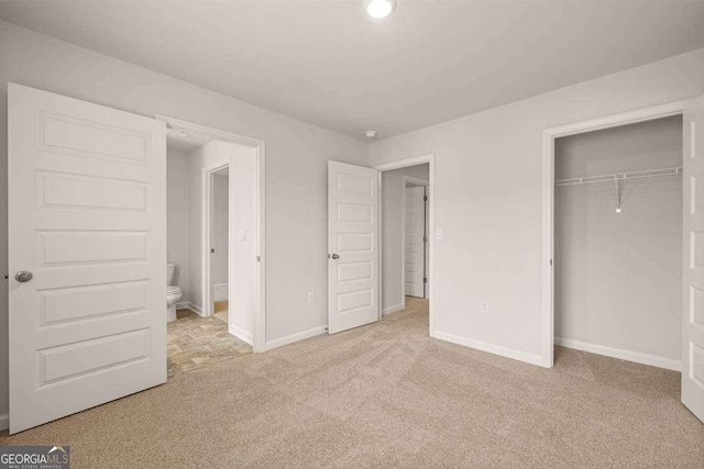 unfurnished bedroom featuring light carpet and a closet