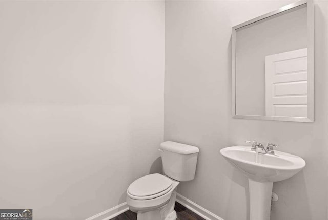 bathroom with hardwood / wood-style floors, sink, and toilet