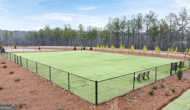 view of tennis court featuring a lawn