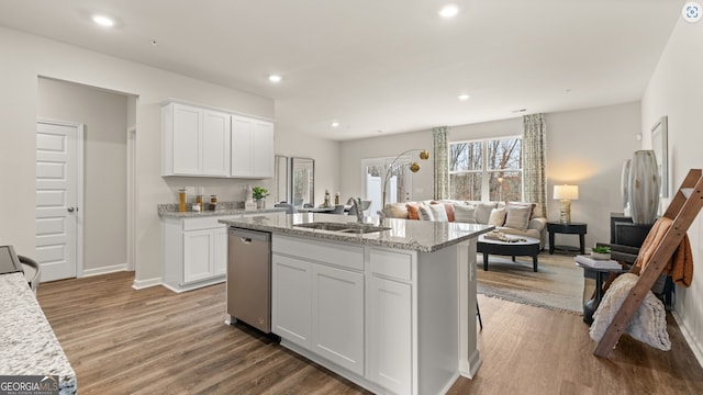 kitchen featuring white cabinets, a center island with sink, dishwasher, and sink