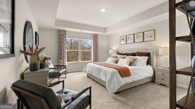 bedroom with light carpet and a tray ceiling