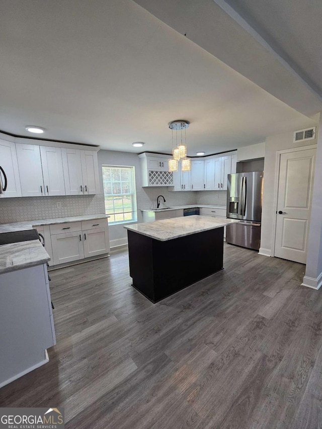 1295 Ga Highway 49, Macon, GA 31211 - kitchen featuring backsplash, stainless steel refrigerator with ice dispenser, visible vents, a center island, and white cabinets