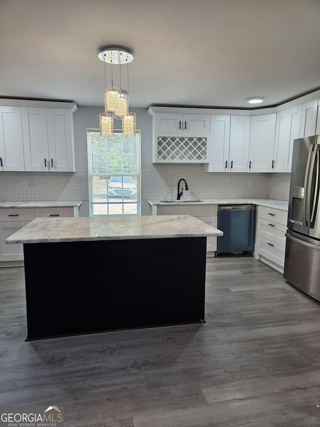 1295 Ga Highway 49, Macon, GA 31211 - kitchen with white cabinets, a sink, appliances with stainless steel finishes, backsplash, and decorative light fixtures