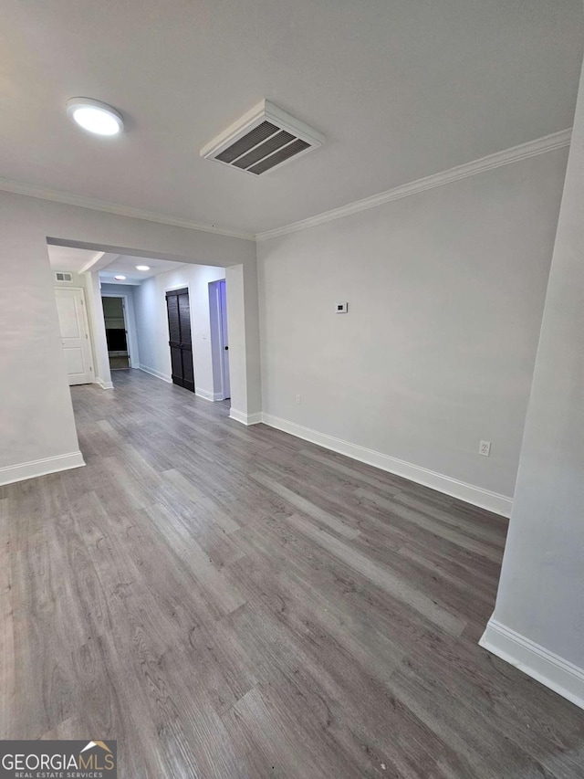 unfurnished living room featuring ornamental molding and wood-type flooring