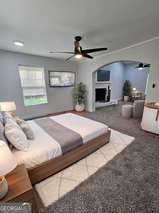 1295 Ga Highway 49, Macon, GA 31211 - bedroom featuring carpet, arched walkways, ceiling fan, and a fireplace with raised hearth