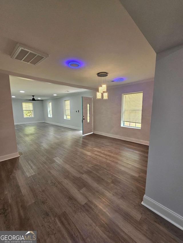 unfurnished living room with dark hardwood / wood-style flooring and ceiling fan with notable chandelier