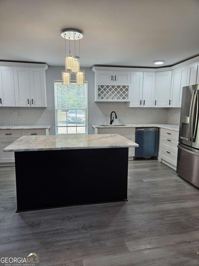 kitchen with sink, white cabinetry, hanging light fixtures, a kitchen island, and stainless steel appliances