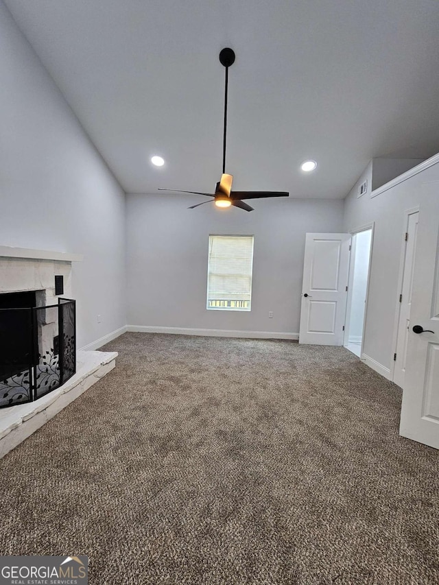 unfurnished living room featuring ceiling fan, carpet, and a fireplace