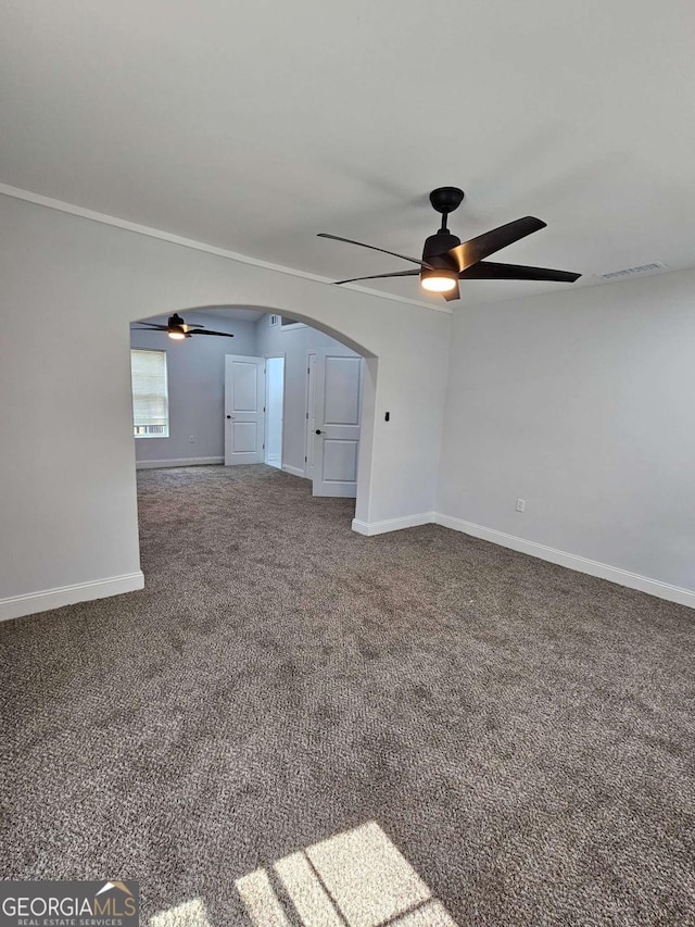 unfurnished living room with ceiling fan, ornamental molding, and carpet floors